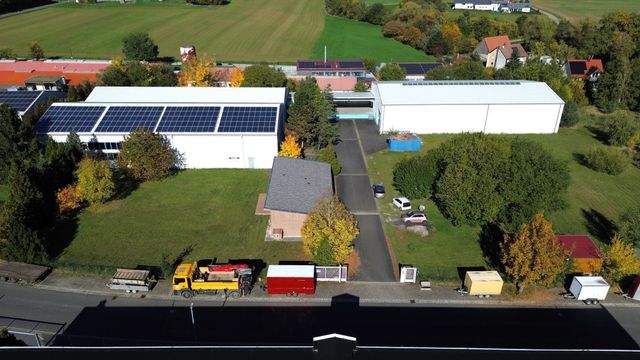 Zwei verbundene Lagerhallen mit Hochregalen und Laderampe - Luftbild